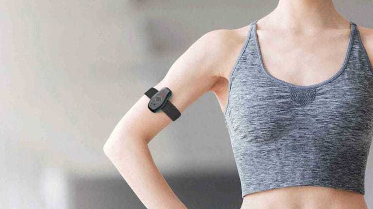 Sweat detector development — wearable biosensor device on arm showing compact form factor and skin-contact design