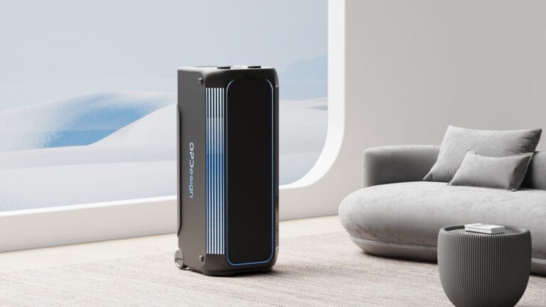 Outdoor speaker development — portable outdoor speaker placed in a modern living room setting next to a sofa, showing multi-scene use